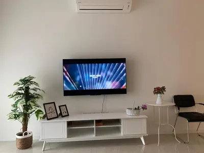 a living room with a tv on a white wall at Quill Residences Service Suites By BR in Kuala Lumpur