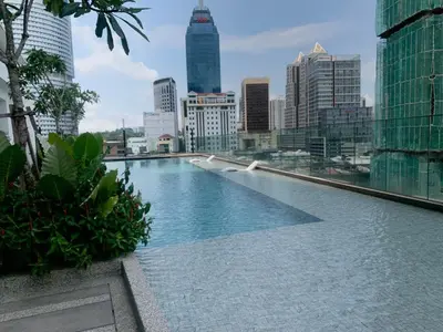 a swimming pool with a city skyline in the background at Quill Residences Service Suites By BR in Kuala Lumpur