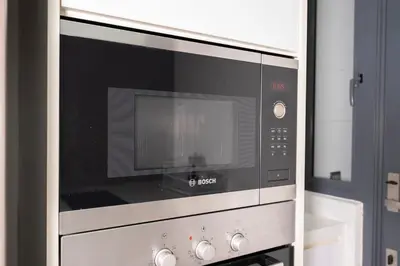 a microwave oven sitting inside of a kitchen at Spacious Family Apt 3-Min Walk to KLCC MRT RO Water Baby Crib Home Cinema Projector in Kuala Lumpur