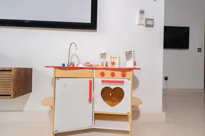 a toy kitchen with a heart on the door at Spacious Family Apt 3-Min Walk to KLCC MRT RO Water Baby Crib Home Cinema Projector in Kuala Lumpur