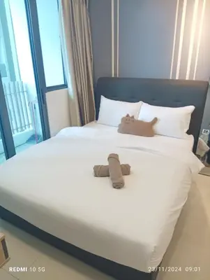 a bed with a stuffed animal sitting on it at The luxe suite service KLCC in Kuala Lumpur