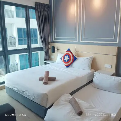two beds in a hotel room with a captain america pillow at The luxe suite service KLCC in Kuala Lumpur