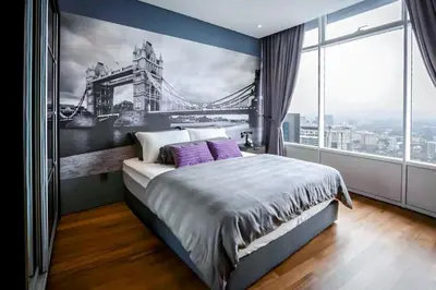 a bedroom with a large bed with a painting of a bridge at Vortex KLCC Vibes in Kuala Lumpur