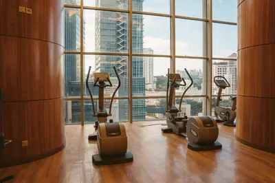 a gym with cardio machines in front of a large window at St Giles Gardens Residences Kuala Lumpur in Kuala Lumpur