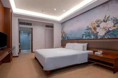 a bedroom with a white bed and a painting on the wall at St Giles Gardens Residences Kuala Lumpur in Kuala Lumpur