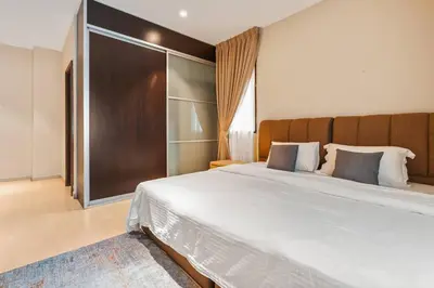 a bedroom with a large bed with a wooden headboard at Retreat In The Heart of KLCC, The Corinthians in Kuala Lumpur