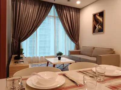 a living room with a couch and a table and chairs at Soho Suites KLCC by Minsha Homes in Kuala Lumpur