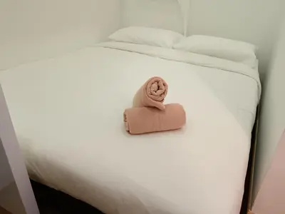 a stuffed animal is sitting on a bed at Soho Suites KLCC by Minsha Homes in Kuala Lumpur