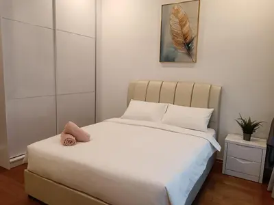 a bedroom with a white bed with a stuffed animal on it at Soho Suites KLCC by Minsha Homes in Kuala Lumpur