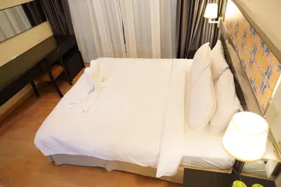 a hotel room with a bed with white sheets and pillows at The Luxe stay Bukit Bintang in Kuala Lumpur