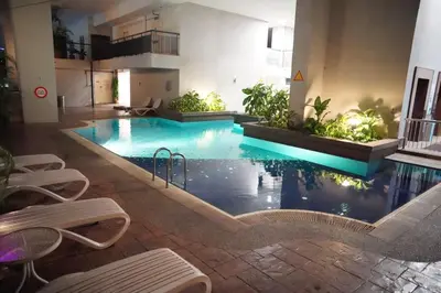 a large swimming pool in a building with chairs around it at The Luxe stay Bukit Bintang in Kuala Lumpur