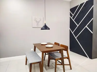 a dining room with a wooden table and chairs at The Luxe stay Bukit Bintang in Kuala Lumpur