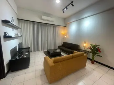 a living room with a couch and a tv at The Luxe stay Bukit Bintang in Kuala Lumpur