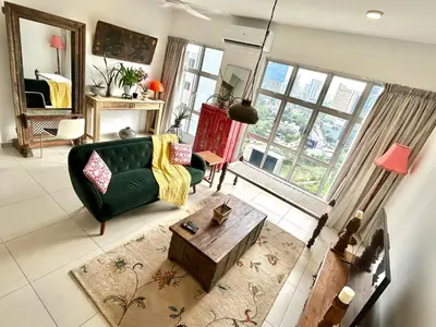 a living room with a green couch and a table at 3 bedroom apt L21 in kl sentral with city view in Kuala Lumpur
