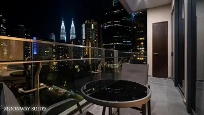 a balcony with a view of the city at night at Harmony Luxury Suites At TM Persiaran Stonor KLCC in Kuala Lumpur