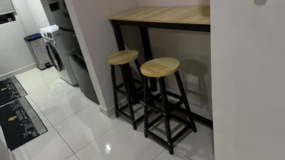 a kitchen with two bar stools and a stove at Datum Jelatek Superb Suite KL By LH in Kuala Lumpur
