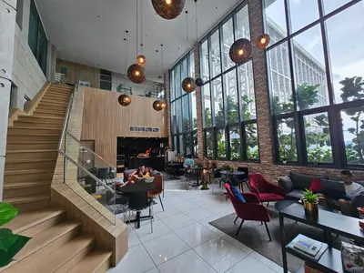 a lobby with a staircase and people sitting at tables at The Luxe by Infinitum KLCC by CASABELLESTAY in Kuala Lumpur