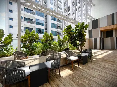a patio with chairs and tables in a building at The Luxe by Infinitum KLCC by CASABELLESTAY in Kuala Lumpur