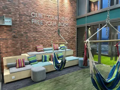 a porch with a swing and pillows in front of a building at KL Sentral Monorail Infinity Sky Pool Family Suites -The RIV in Kuala Lumpur