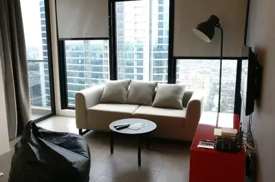 a living room with a couch in front of windows at 3min Bangsar LRT-1 Station to KL Sentral-SuperView in Kuala Lumpur