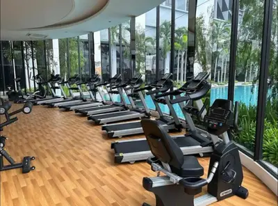 a gym with a row of treadmills and exercise bikes at Trion klcc view apartment near TRX in Kuala Lumpur