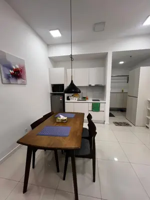 a kitchen and dining room with a wooden table and chairs at The Luxe Stay Chamber KL in Kuala Lumpur