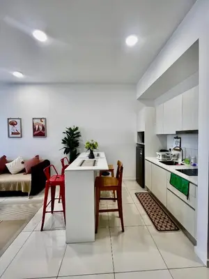 a kitchen and living room with a table and chairs at The Luxe Stay Chamber KL in Kuala Lumpur