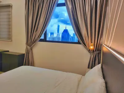 a bedroom with a window with a view of the city at The Luxe Stay Chamber KL in Kuala Lumpur