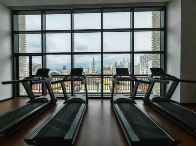 a gym with a view of a city from a large window at Chamber Suite Klcc & KL Tower view in Kuala Lumpur