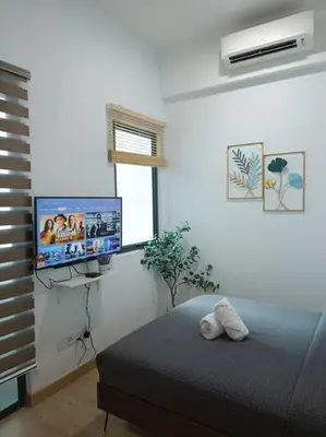 a bedroom with a bed and a flat screen tv at COL 31B Modern Infinity Pool KLCC View in Kuala Lumpur