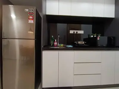 a kitchen with a stainless steel refrigerator and white cabinets at COL 108A Modern KLCC Balcony View & Infinity Pool in Kuala Lumpur