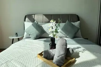 a bed with a vase of flowers on top of it at Premium Living Sky Suites - Twin Towers KLCC 2-min walk in Kuala Lumpur