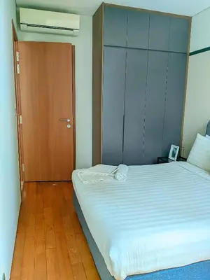 a bedroom with a large bed and a wooden door at vortex Suites KLCC in Kuala Lumpur