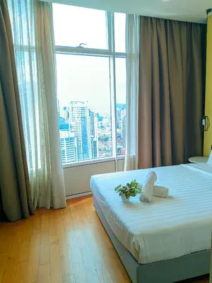 a hotel room with a bed and a large window at vortex Suites KLCC in Kuala Lumpur