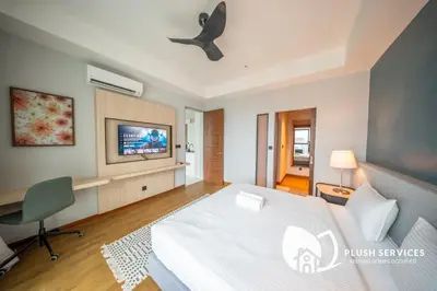 a bedroom with a bed and a tv on the wall at Alfa Bangsar by Plush in Kuala Lumpur