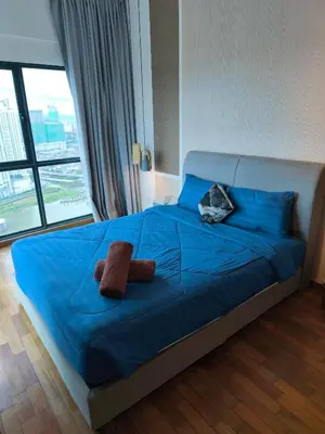 a bedroom with a blue bed with two towels on it at Reizz Residence Majesty Suite in Kuala Lumpur
