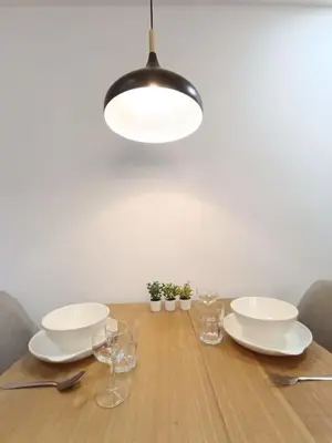 a dining room table with white dishes and a light fixture at COL 171A Modern Balcony KLCC View & Infinity Pool in Kuala Lumpur