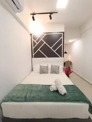 a bedroom with a large white bed with a green blanket at COL 171A Modern Balcony KLCC View & Infinity Pool in Kuala Lumpur