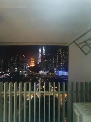 a view of a city at night from a window at COL 171B KLCC Balcony View & Infinity Pool in Kuala Lumpur