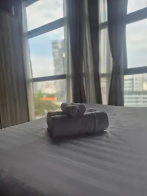 a pair of towels sitting on a bed with a window at 3 Towers Jalan Ampang KL in Kuala Lumpur