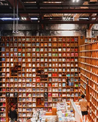 a wall of books in a room with people standing in front at Hi\u8212\u9002\u5927\u5e8a\u623f klcc\u65c1 \u8f7b\u8f68\u65c1 \u65e0\u8fb9\u6e38\u6cf3\u6c60 in Kuala Lumpur