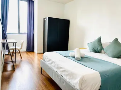 a bedroom with a large bed with green and white pillows at Hi\u8212\u9002\u5927\u5e8a\u623f klcc\u65c1 \u8f7b\u8f68\u65c1 \u65e0\u8fb9\u6e38\u6cf3\u6c60 in Kuala Lumpur