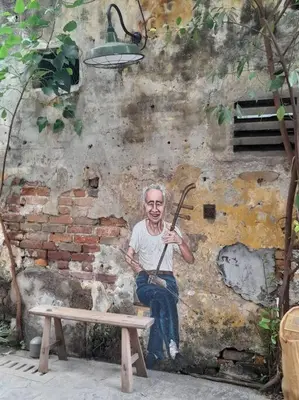 a painting of a man sitting on a wall with a bench at Cozy Idaman Robertson Suite Balcony in Kuala Lumpur