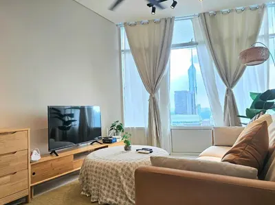 a living room with a couch and a large window at The Sky Residence KLCC by AsianHost in Kuala Lumpur