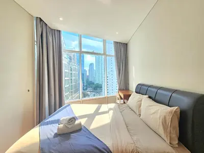a hotel room with a bed and a large window at The Sky Residence KLCC by AsianHost in Kuala Lumpur