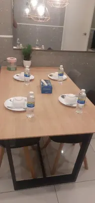 a wooden table with plates and water bottles on it at STAY WITH DAy CAUCON in Kuala Lumpur