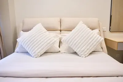 a bed with white pillows on top of it at Agile Bukit Bintang KLCC by Plush in Kuala Lumpur