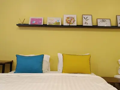 a bed with two blue and yellow pillows on it at Fahrenheit 88 in Kuala Lumpur