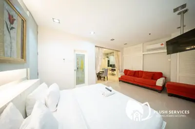 a bedroom with a white bed and a red couch at Parkview KLCC, Bukit Bintang in Kuala Lumpur
