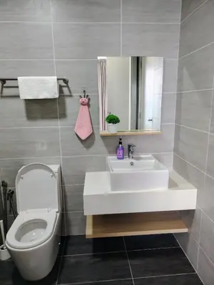 a bathroom with a sink and a toilet and a mirror at Trion Residence Kuala Lumpur by Luxe in Kuala Lumpur